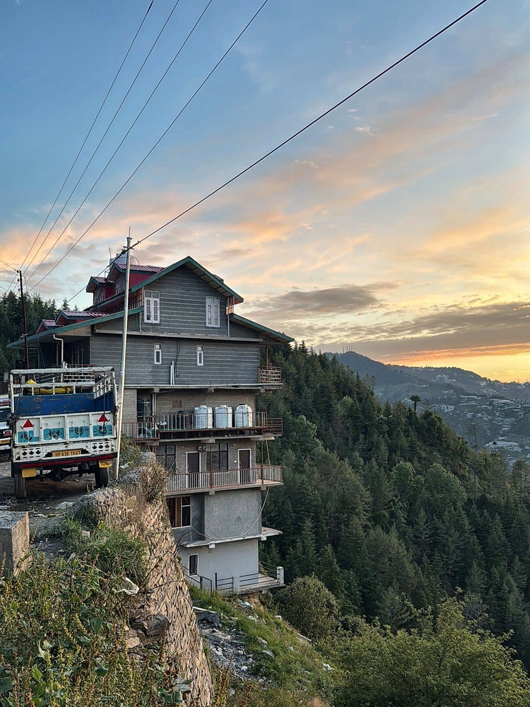 Pinewood homestay building beside the road with the valley and evening sky behind it