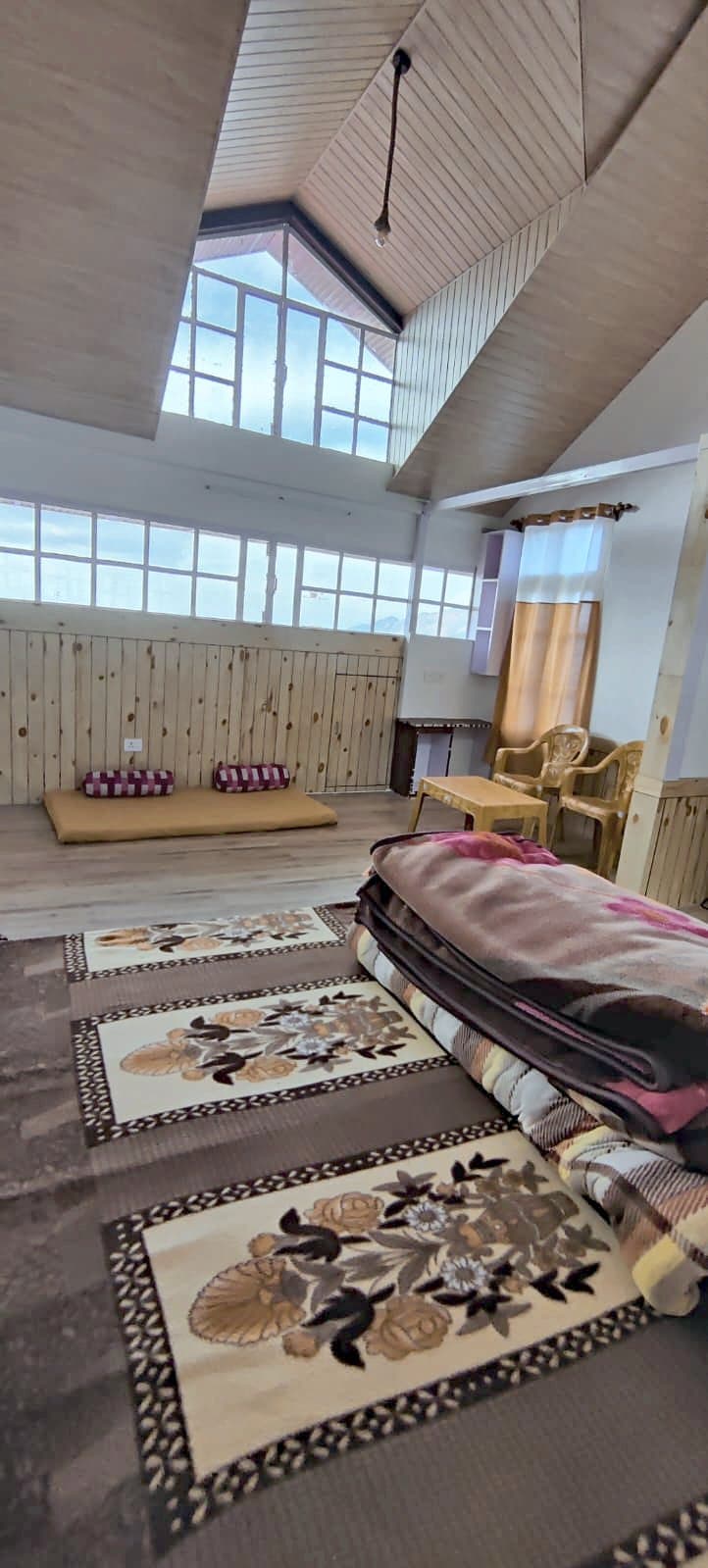 Spacious room with a high wooden ceiling and rugs at Pinewood