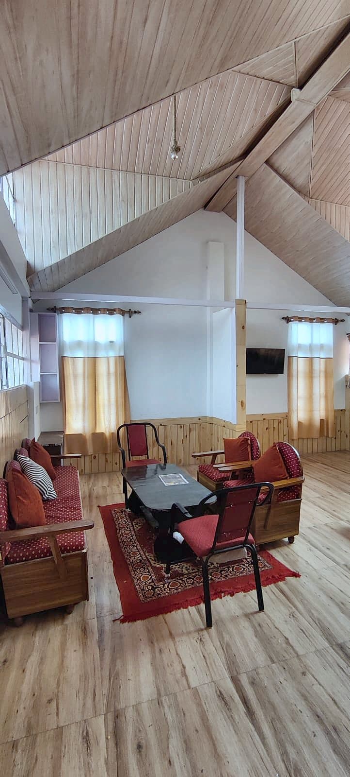 Sofa set and table in the wooden attic room at Pinewood