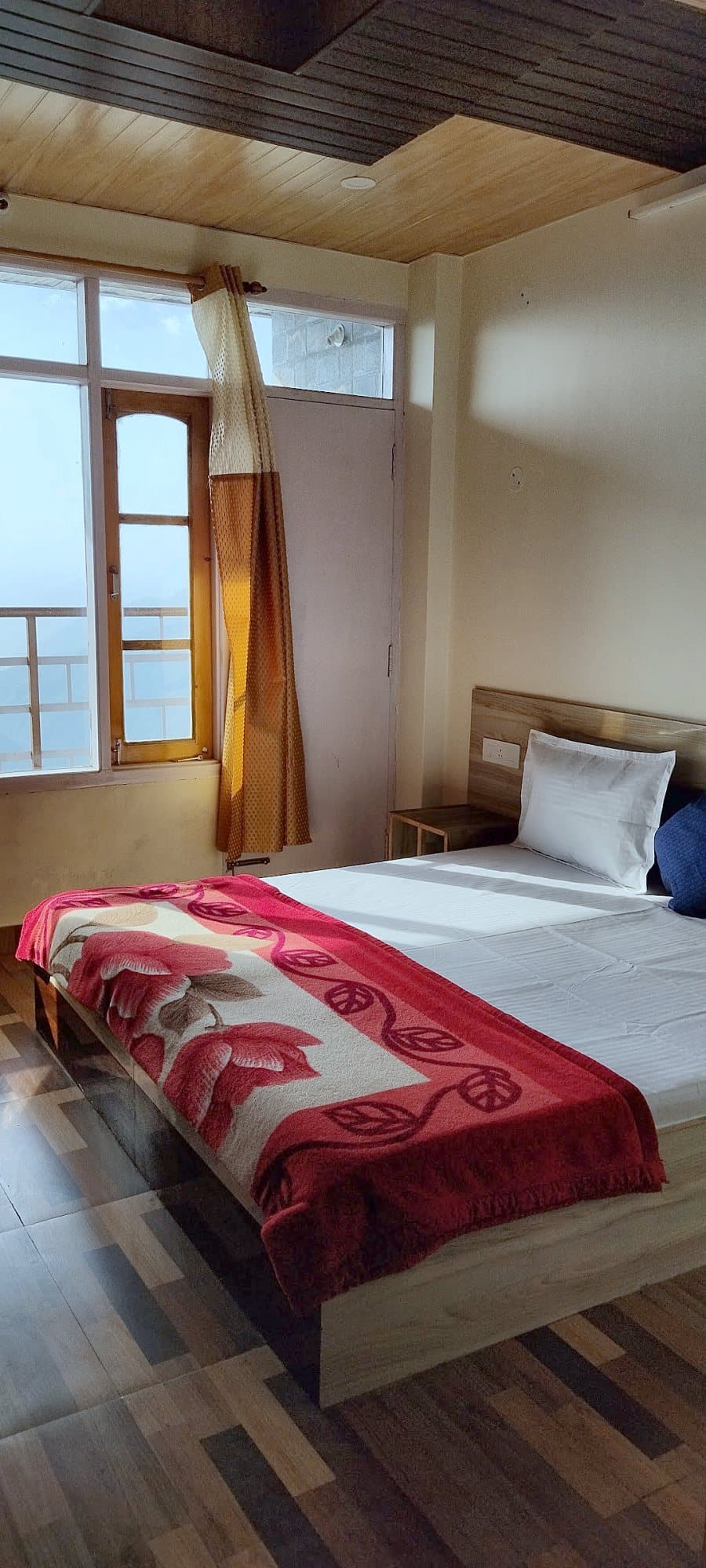 Bed beside a window letting in daylight at Pinewood
