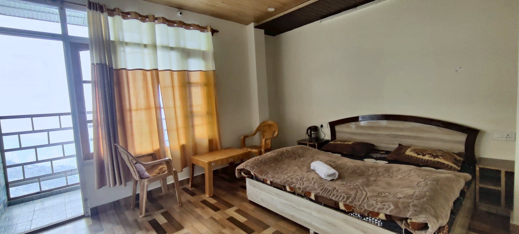 Bedroom at Pinewood with a double bed, wooden floor and curtains