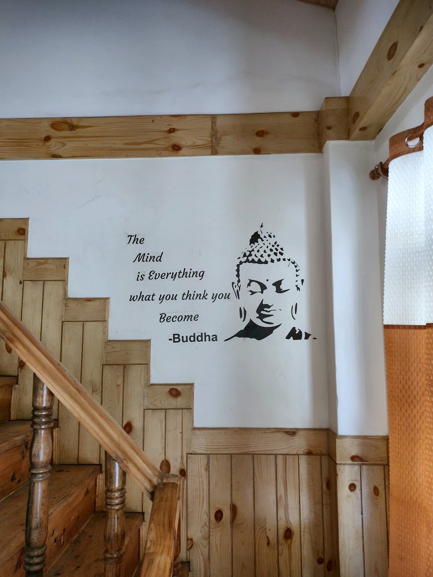 Wooden staircase at Pinewood with a Buddha quote painted on the wall