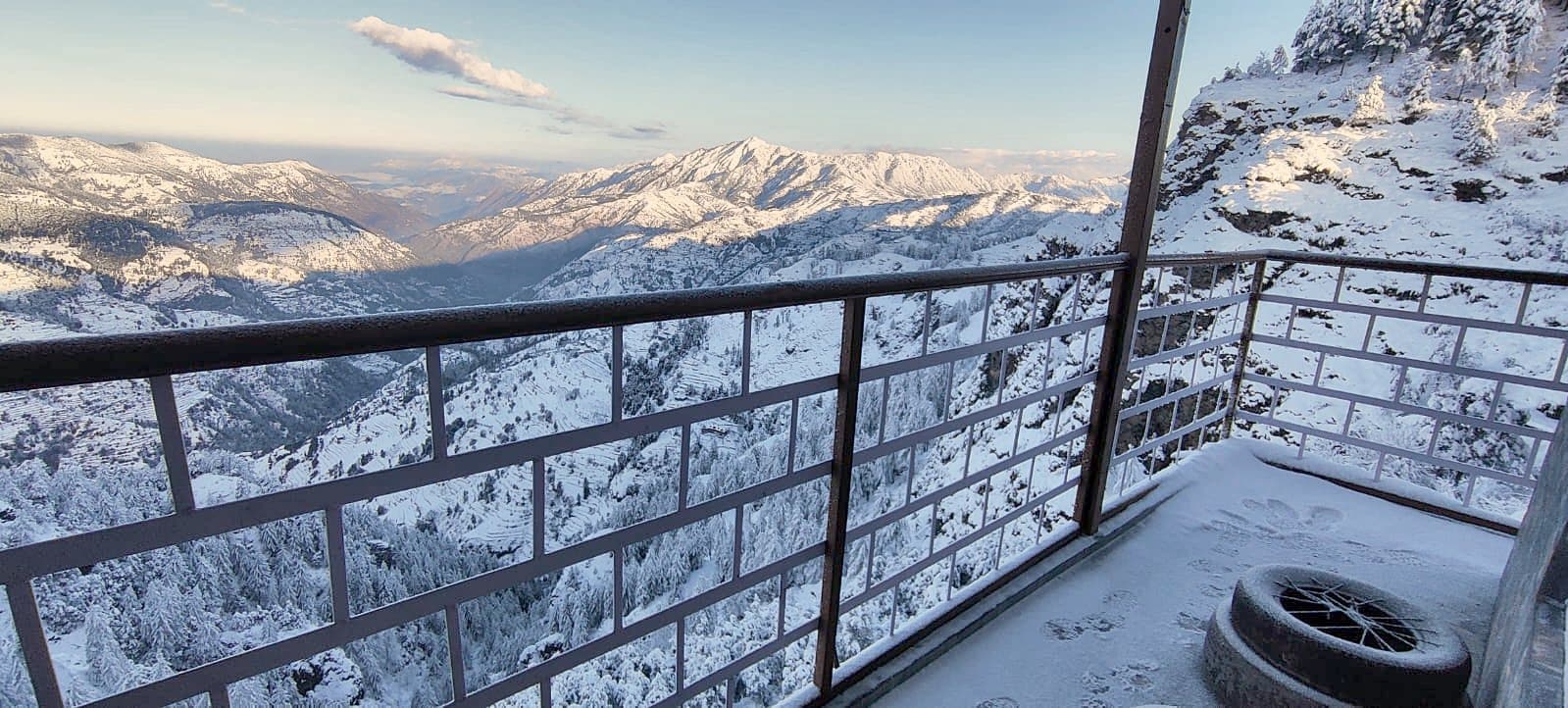 Snow-covered hills seen from a balcony railing at Pinewood